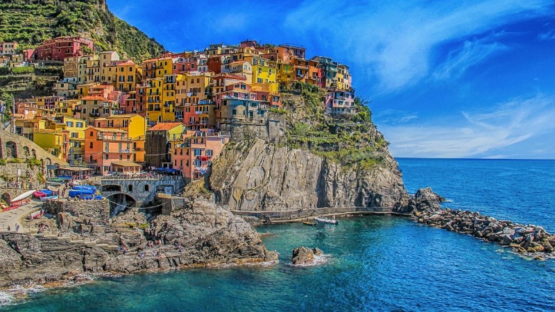 Vivid view of Manarola's colorful houses perched on cliffs, overlooking the blue sea., tags: la - pexel