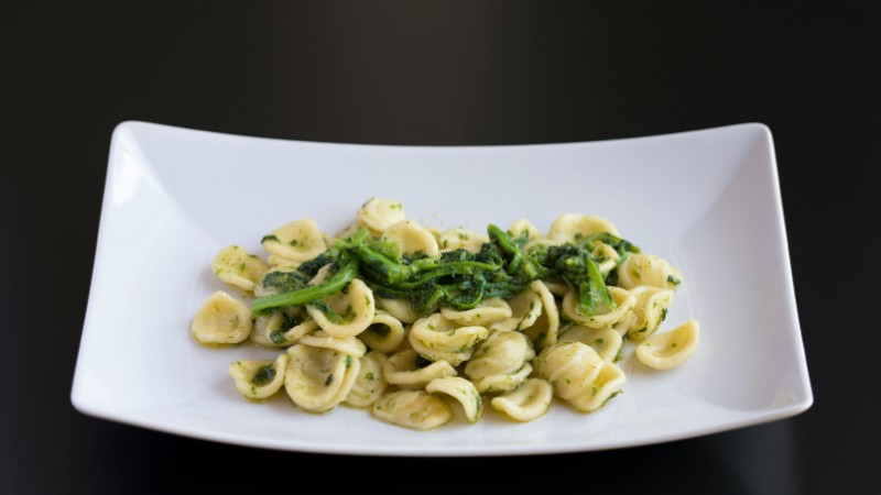 Close-up of orecchiette pasta with greens elegantly plated, showcasing vibrant colors and delicious presentation., tags: la cucina italiana il del - pexel